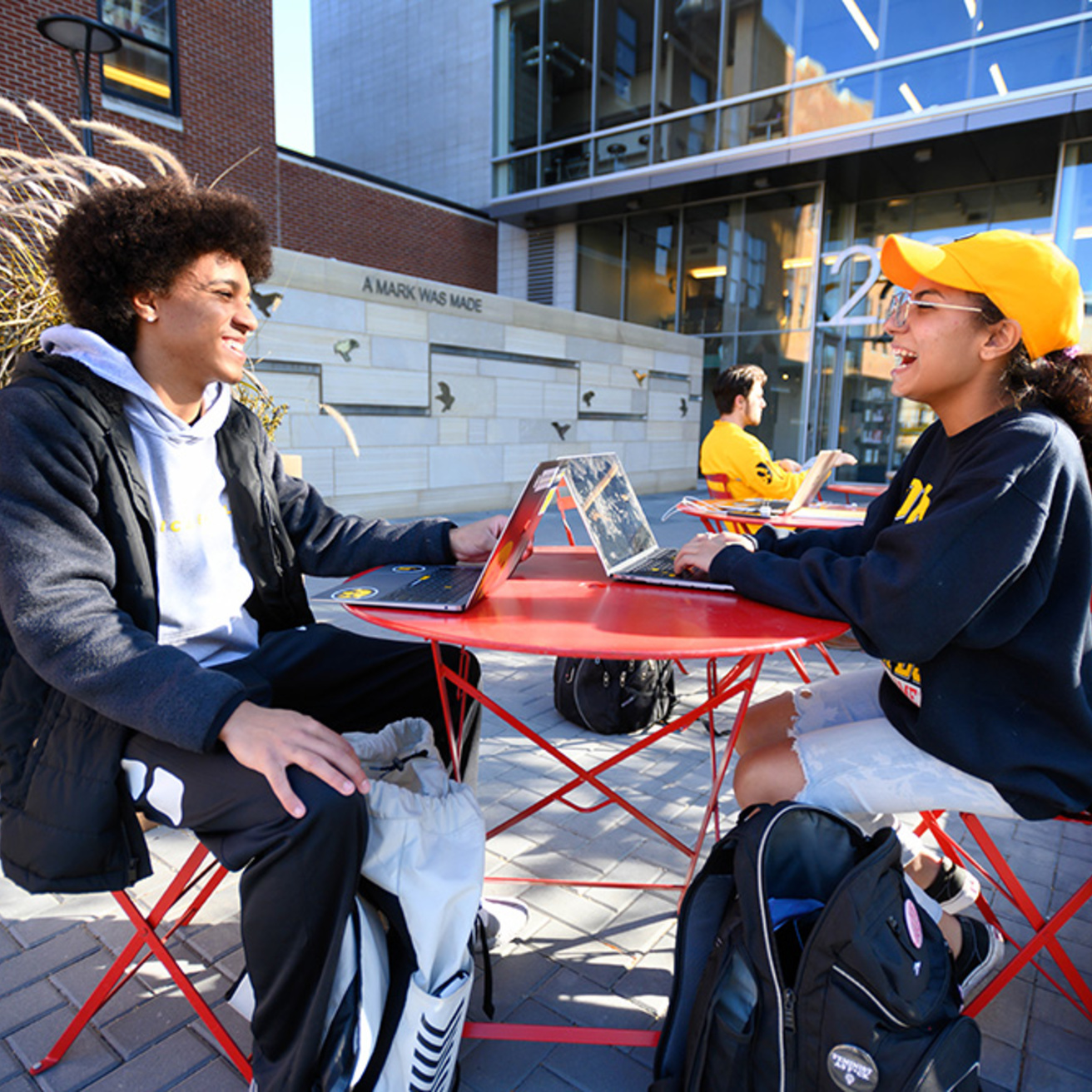 Two students sitting and talking downtown on pedmall