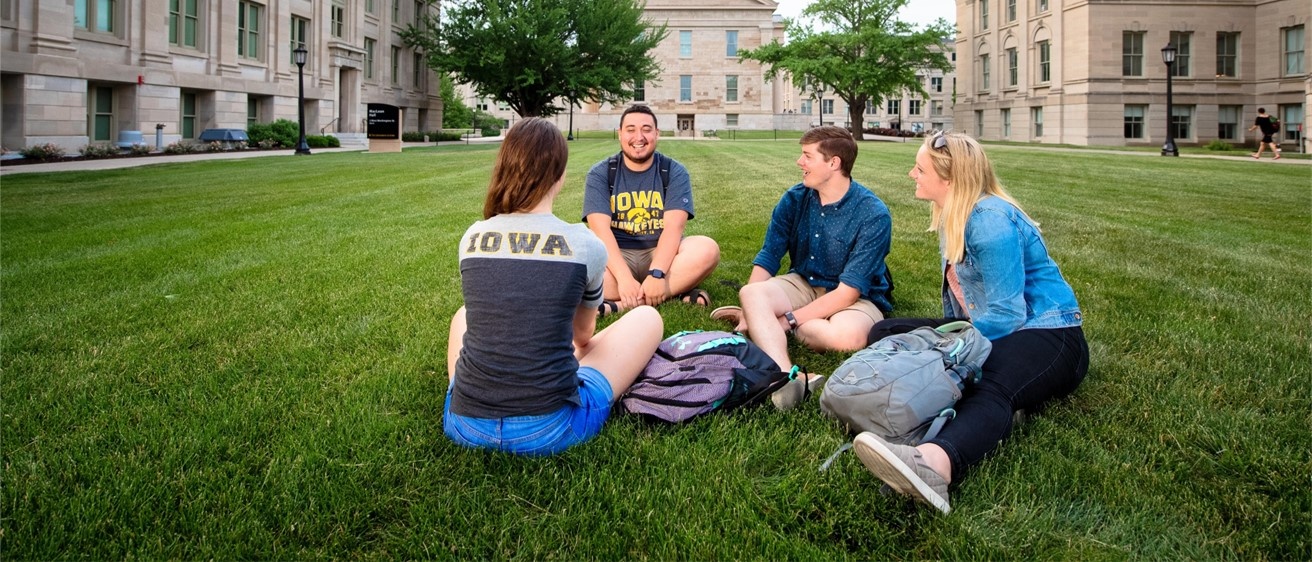 student discussion group sitting on campus lawn
